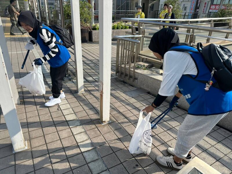 2人の女性が駅の構内でゴミを拾っている